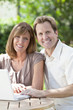 Man & Woman Couple Using Laptop Computer In Garden