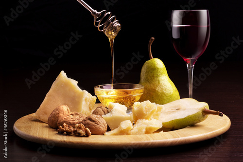 Photo: cheese, pears, honey, walnuts and wineglass cheese, pears, honey, walnuts and wineglass