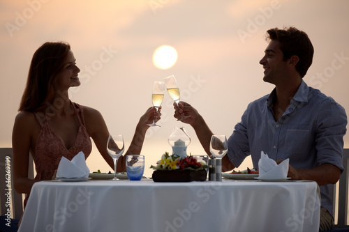 Photo: Romantic moments - Couple at beach sunset enjoying dinner Romantic moments - Couple at beach sunset enjoying dinner