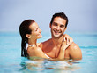 Lovely young couple in the sea having fun