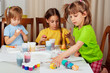 Photo: Three little girls (sisters) painting on Easter eggs Three little girls (sisters) painting on Easter eggs