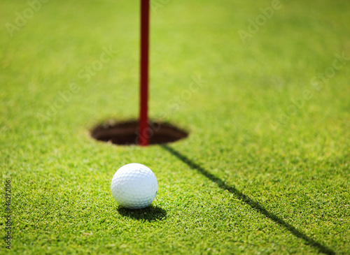 Photo: golf ball on lip of cup golf ball on lip of cup