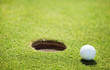 golf ball on lip of cup