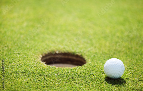 Photo: golf ball on lip of cup golf ball on lip of cup