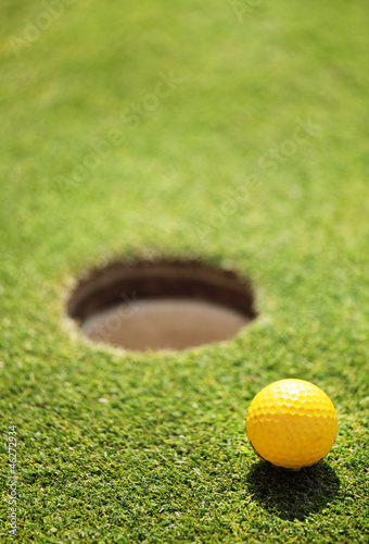 Photo: golf ball on lip of cup golf ball on lip of cup