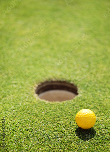Photo: golf ball on lip of cup golf ball on lip of cup