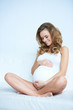 Photo: Beautiful pregnant woman sitting on couch Beautiful pregnant woman sitting on couch