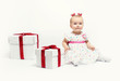 Adorable baby girl with two gift boxes