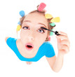 Funny portrait of girl applying mascara