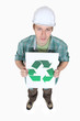Tradesman holding a sign displaying the recycling symbol