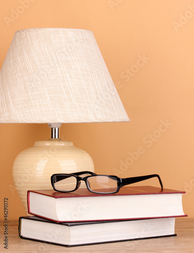 Photo: table lamp and books on beige background table lamp and books on beige background