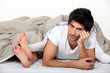 Annoyed man lying next to a woman in bed