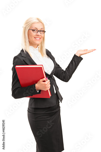 Photo: A young teacher holding a book and showing A young teacher holding a book and showing