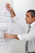 Architect looking at plans on a wall