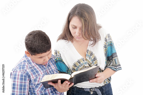 Photo: Mother and son reading a Bible over a black background Mother and son reading a Bible over a black background
