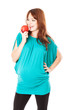 A pregnant smiling woman is holding an apple in her hand