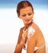 Woman applying lotion on body