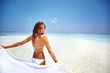Woman enjoying windy beach with sarong