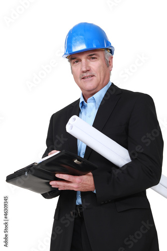 Photo: A mature architect with a planner. A mature architect with a planner.