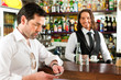 Barista mit Gast in seinem Cafe oder Coffeeshop