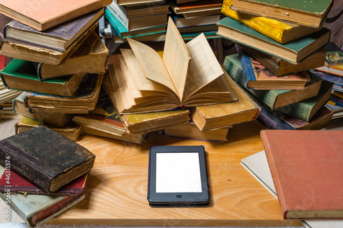 Photo: Ebook and old books on table Ebook and old books on table