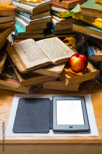 Photo: Ebook and old books on table Ebook and old books on table