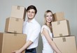 Happy young couple holding stack of cardboard boxes