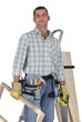 Carpenter standing by a ladder