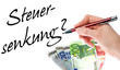 Hand mit Stift schreibt das Wort Steuersenkung