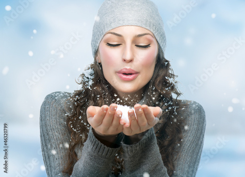 Photo: Christmas Girl. Winter woman Blowing Snow Christmas Girl. Winter woman Blowing Snow