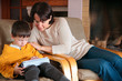Photo: Mother and son playing on digital tablet PC Mother and son playing on digital tablet PC