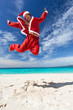 Santa Claus jumps on tropical beach