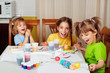 Photo: Three little girls (sisters) painting on Easter eggs Three little girls (sisters) painting on Easter eggs