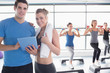 Trainer and woman smiling together during aerobics class