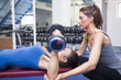 Female trainer helping client lifting weights