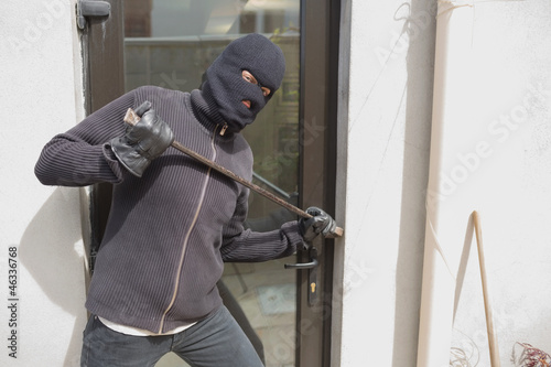 Photo: Robber breaking into house using crow bar Robber breaking into house using crow bar