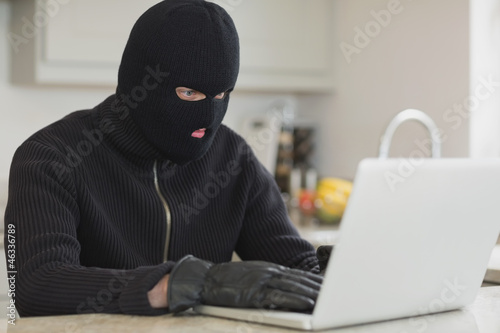 Photo: Burglar hacking a laptop Burglar hacking a laptop