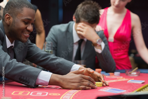 Photo: Man winning jackpot as other man is being comforted by woman Man winning jackpot as other man is being comforted by woman