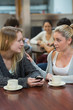 Student comforting upset friend with mobile phone