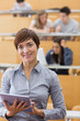 Woman standing holding a tablet computer smiling