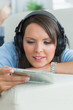 Photo: Woman listening music and looking at cd on sofa Woman listening music and looking at cd on sofa