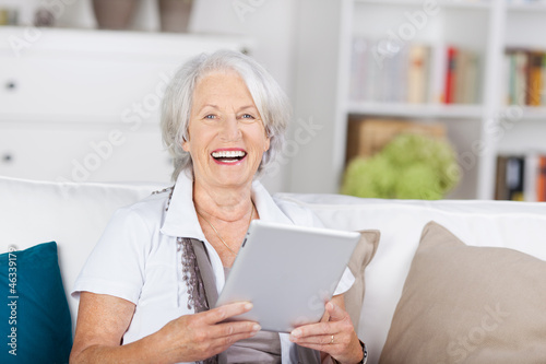 Photo: lachende ältere dame mit tablet-pc lachende ältere dame mit tablet-pc