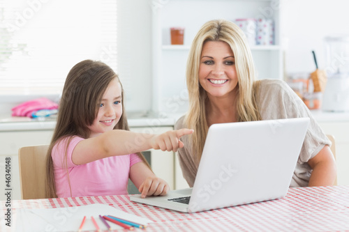 Photo: Daughter pointing at laptop with mother Daughter pointing at laptop with mother