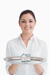 Smiling waitress holding tray with miniature house