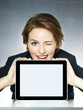 Business woman winking over her tablet pc with copyspace