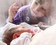 Photo: Newborn baby girl in a incubator. Her sister looking at. Newborn baby girl in a incubator. Her sister looking at.