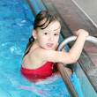 Foto: Happy child bathing in a swimming pool. Happy child bathing in a swimming pool.