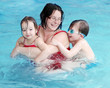 Photo: Happy family playing in a swimming pool. Happy family playing in a swimming pool.