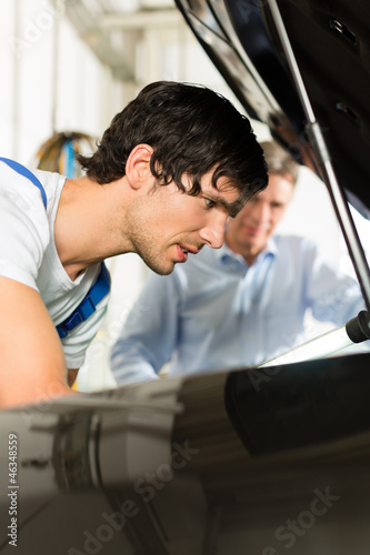Photo: Kunde und Mechaniker an Auto schauen unter Haube Kunde und Mechaniker an Auto schauen unter Haube