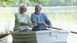 Smiling Caucasian couple rowing boat on river